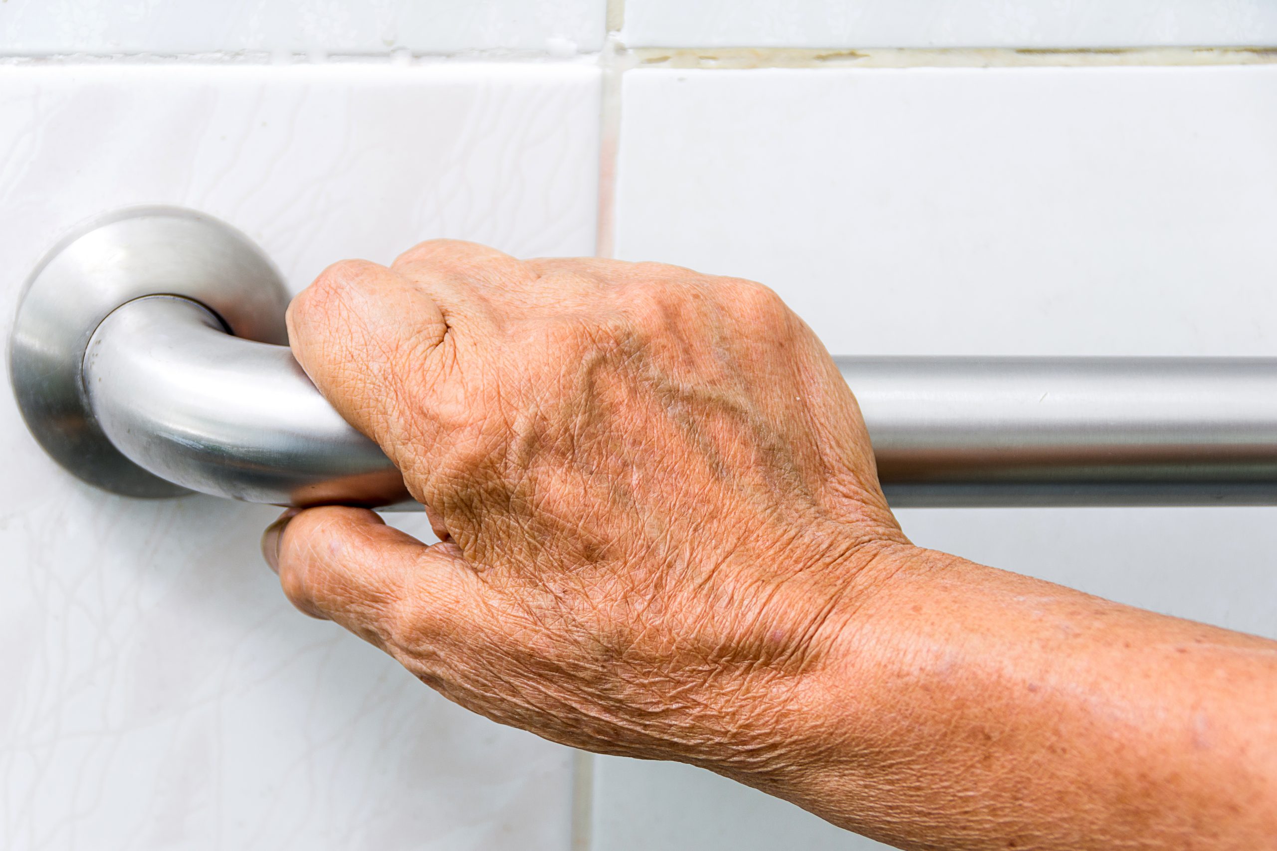 Hand holding a shower metal accessibility bar © Myibean