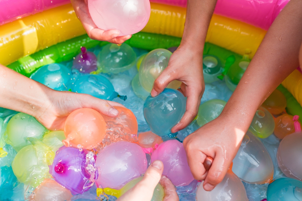 Kids holding balloons for water balloon fight ©Tatiana Gordievskaia